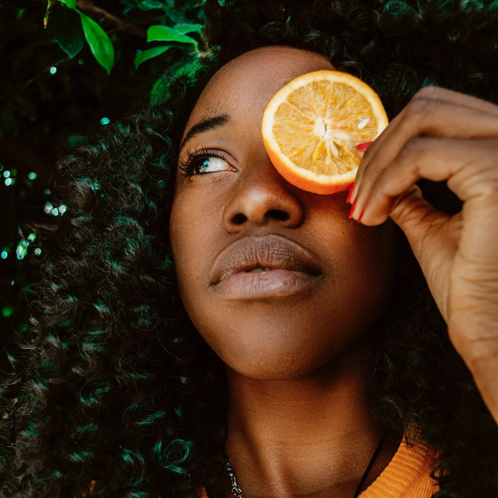 woman holding a slice of orange